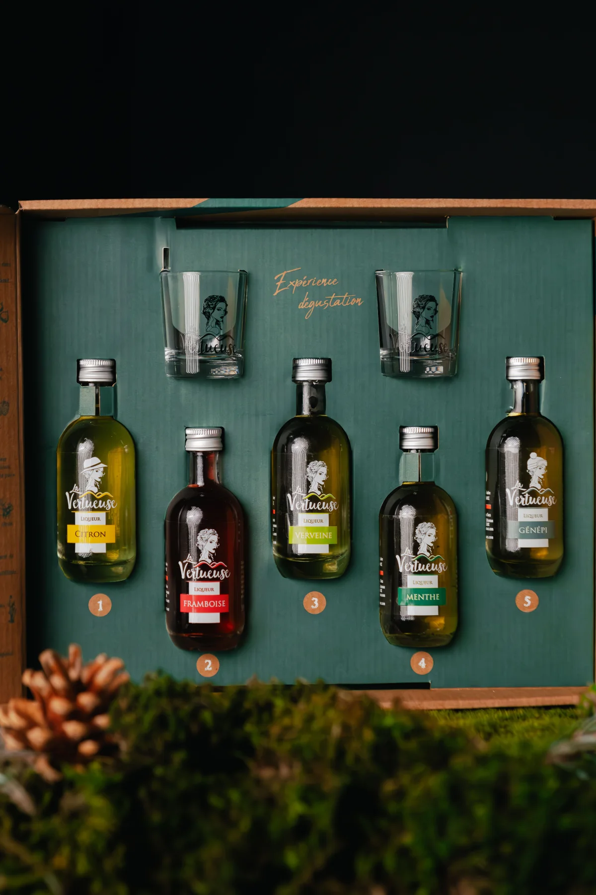 Gamme de liqueurs La Vertueuse présentée dans un décor végétal